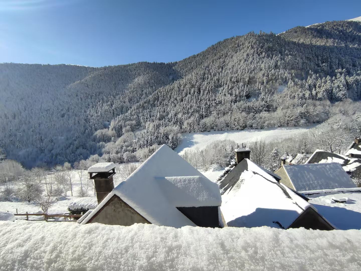 Les toits du village sous la neige, face à la montagne